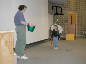 Volunteer from audience helps with science demonstration