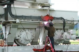 Technician doing welding work on a GBT track truck