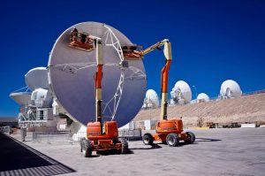 Engineers adjusting an ALMA antenna's surface panels