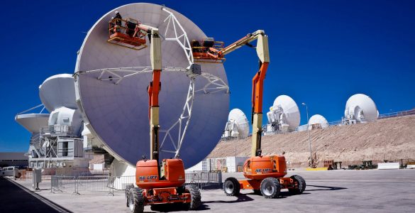 Engineers adjusting an ALMA antenna's surface panels