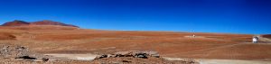 ALMA antennas on distant pads with the central antennas in the background.