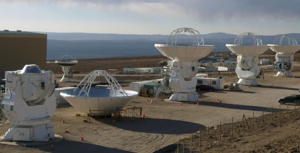 Photo of three completed and one incomplete ALMA antennas.