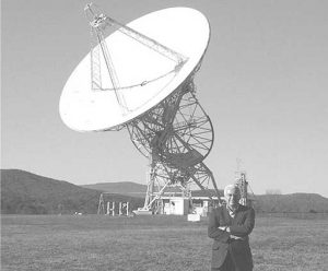 Dr. Frank Drake poses with the telescope he used to search for signs of extraterrestrial intelligence in space.