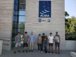 group photo of students and scientists in front of Alma and NINS sign