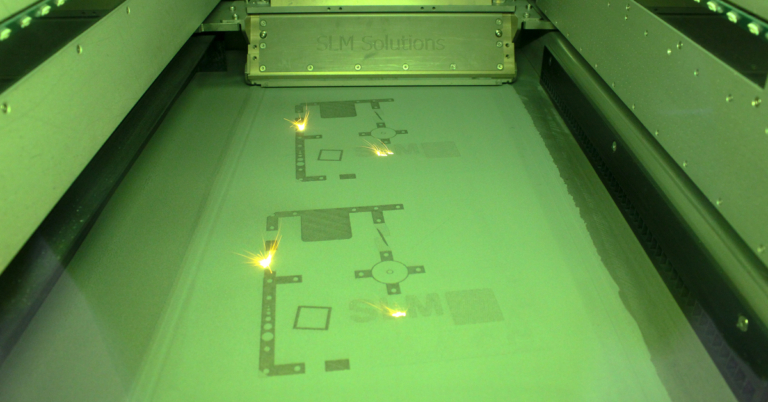 Sparks from the welding process in a 3D metal printer as it fuses shapes for objects and devices