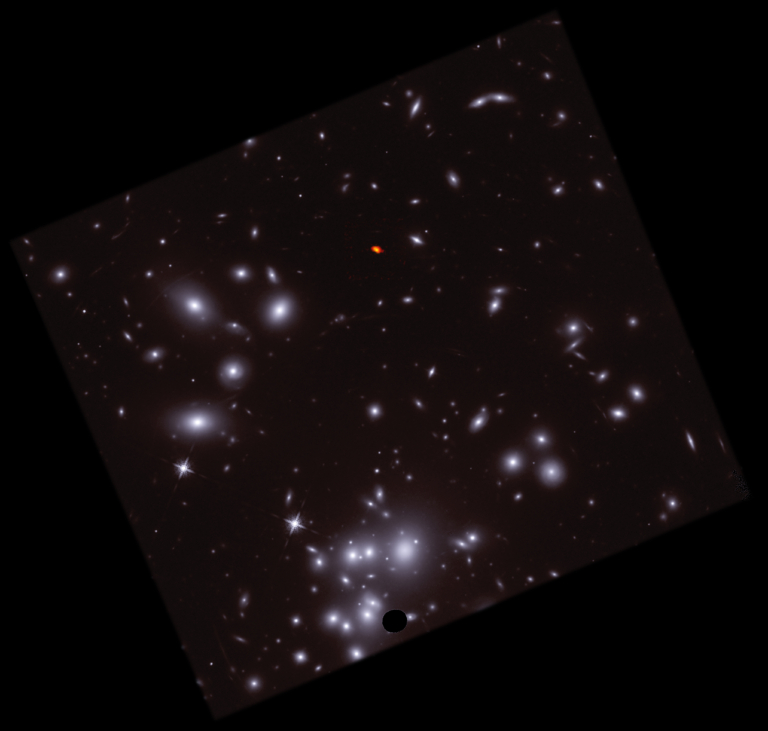 large star field of Virgo constellation cluster shown in blue and white, with tiny bean-shaped galaxy shown in red and orange radio light